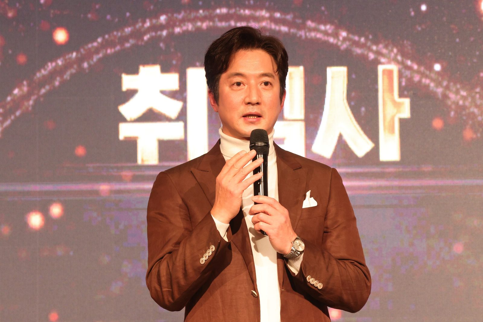 만남day 행사 무대에서 마이크를 들고 말하는 모습(2024.12.27 롯데호텔 크리스탈볼룸)