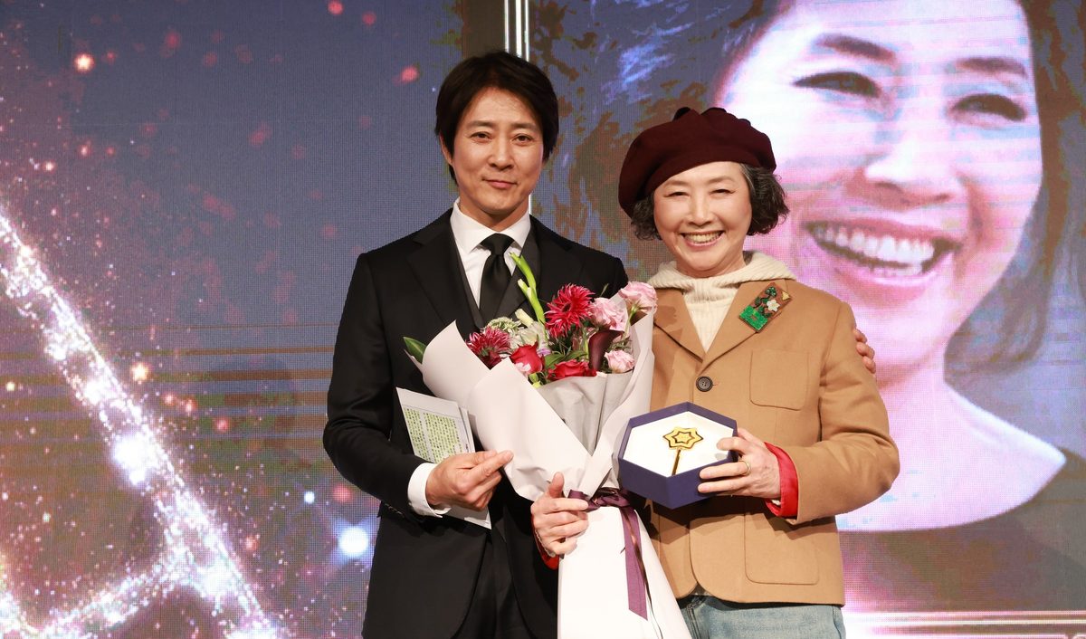 만남day 행사 무대에서 꽃다발과 기념패를 든 두 사람(2024.12.27 롯데호텔 크리스탈볼룸)